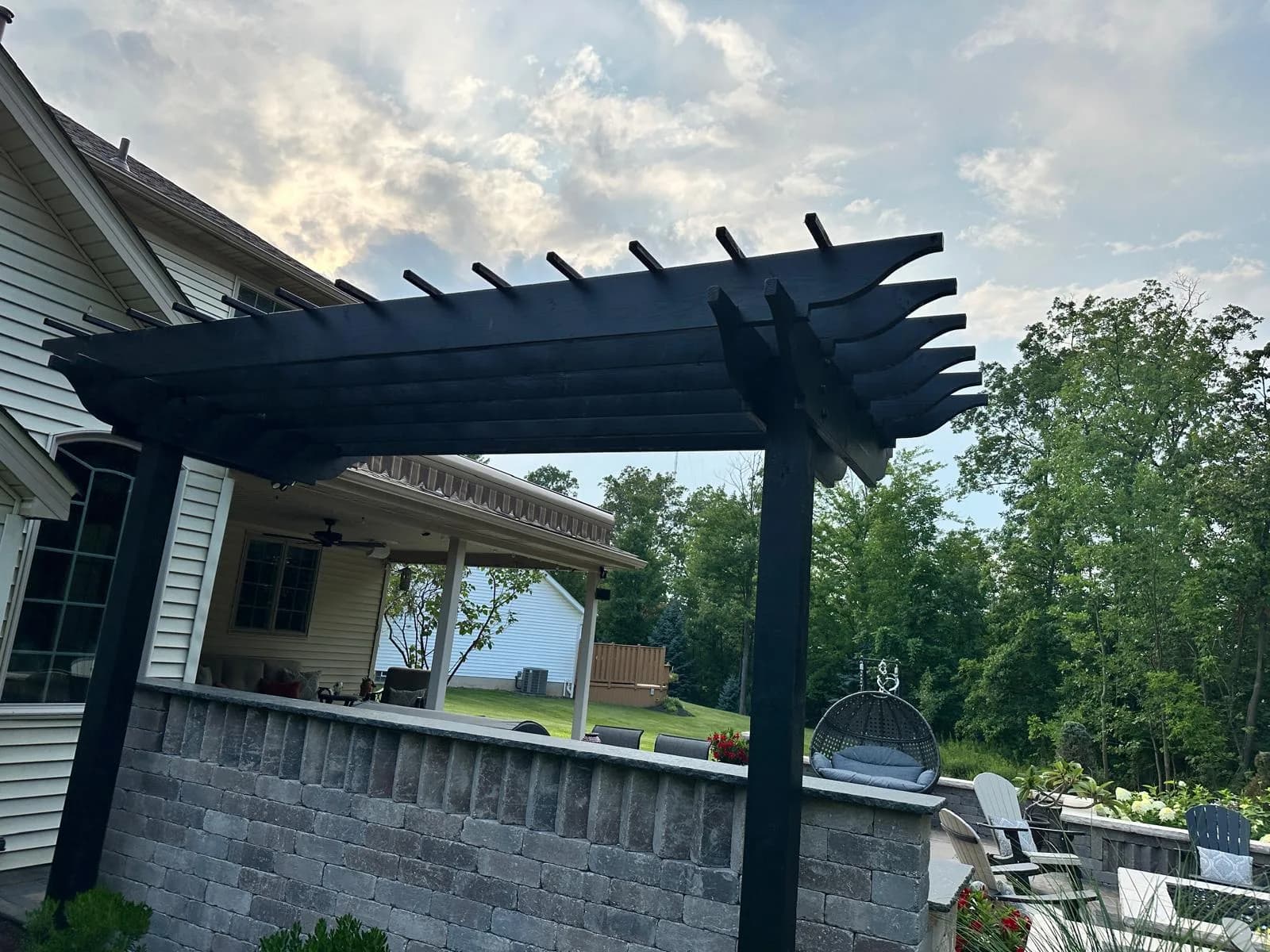 Black pergola with patio furniture — Buffalo NY