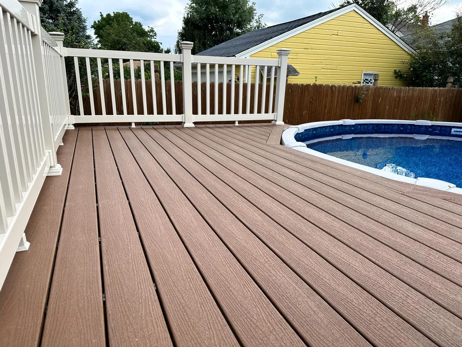 Composite deck wrapping around pool — Buffalo NY